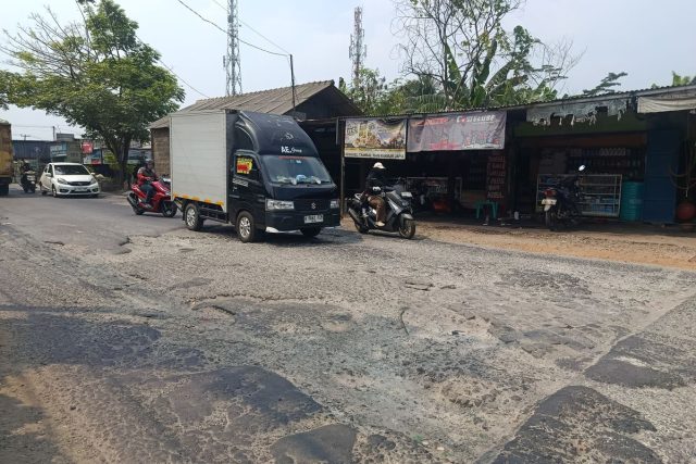 Sejumlah kendaraan melintasi ruas Jalan MT Haryono di Desa Ciledug, Kecamatan Setu, Kabupaten Bekasi, Jumat (24/7/2026). Kondisi jalan yang bergelombang, berlubang, dan dipenuhi kerikil membuat pengendara harus mengurangi kecepatan saat melintas